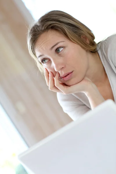 Mulher ativa na frente do laptop com olhar chateado — Fotografia de Stock