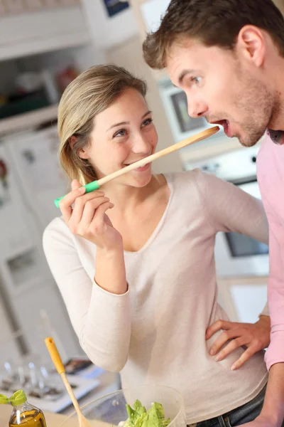 Couple enjoying preparing dinner in kitchen — Stock Photo, Image