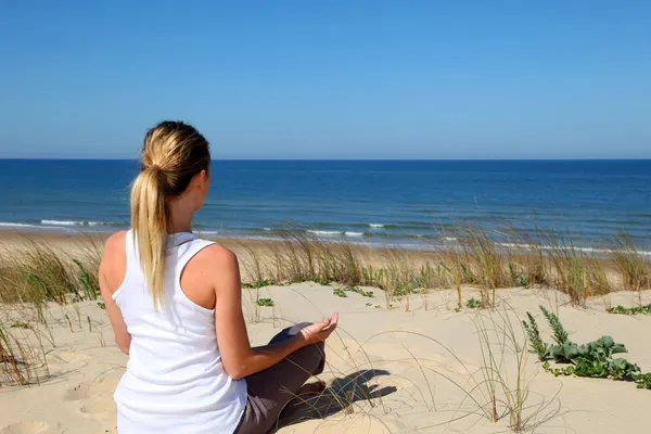 Vrouw oefenen yoga op het strand — Stockfoto