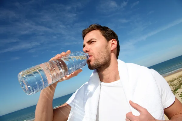Porträt eines Joggers, der Wasser aus der Flasche trinkt — Stockfoto