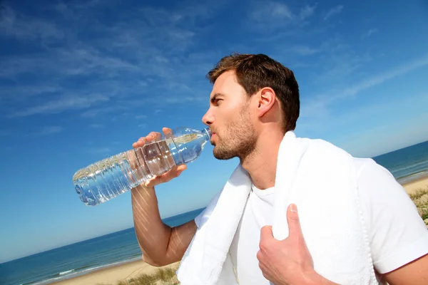 Porträt eines Joggers, der Wasser aus der Flasche trinkt — Stockfoto