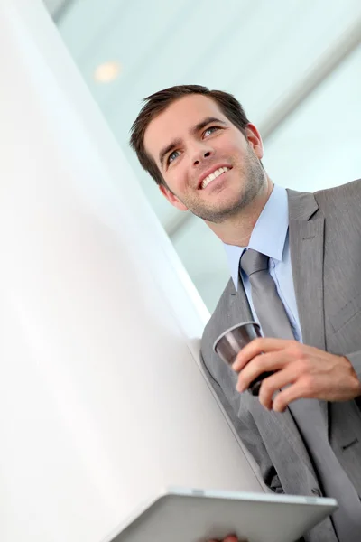 Portrét podnikatele pití kávy v chodbě — Stock fotografie