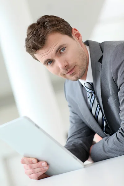 Uomo d'affari in attesa in corridoio con tablet elettronico — Foto Stock