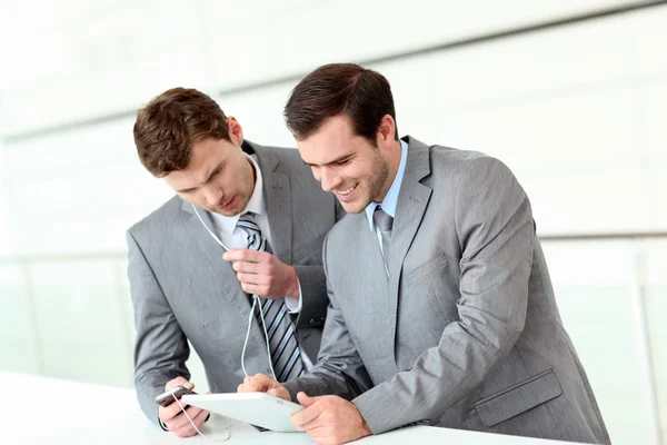 Business partners working in hallway with electronic tablet — Stock Photo, Image