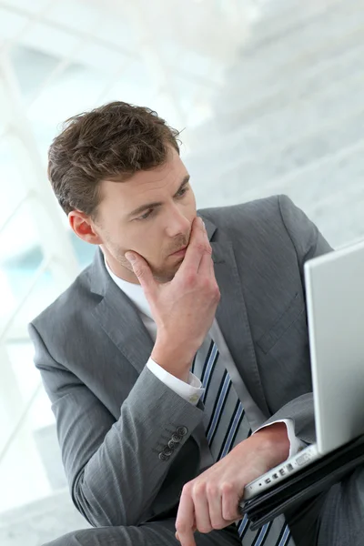 Portret van bezorgd zakenman zit voor laptop — Stockfoto