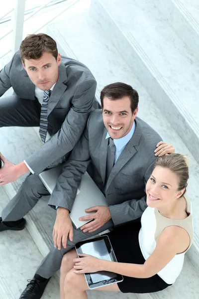 Upper view of business team sitting in stairs — Stock Photo, Image