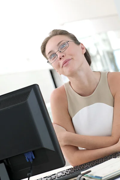 Piękna kobieta z okularów siedzi w biurze — Zdjęcie stockowe