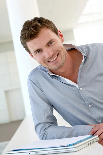 Smiling handsome guy standing in hallway — Stock Photo, Image