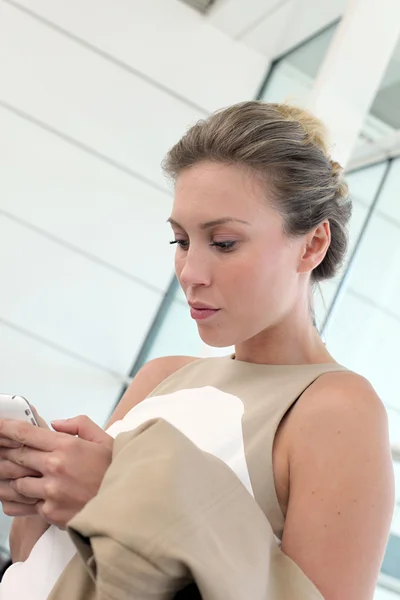 Active businesswoman in airport with smartphone — Stock Photo, Image