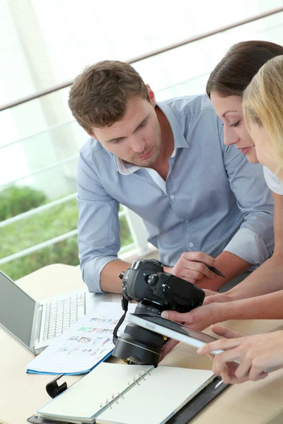 Equipo de reporteros fotográficos trabajando en la oficina — Foto de Stock