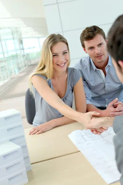 Couple serrant la main à l'agent immobilier au bureau — Photo