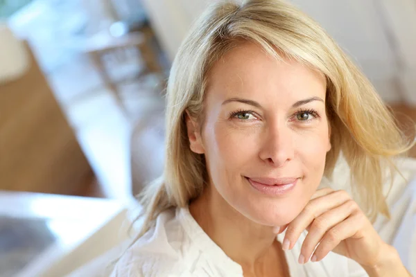 Portrait of blond mature woman relaxing in sofa — Stock Photo, Image