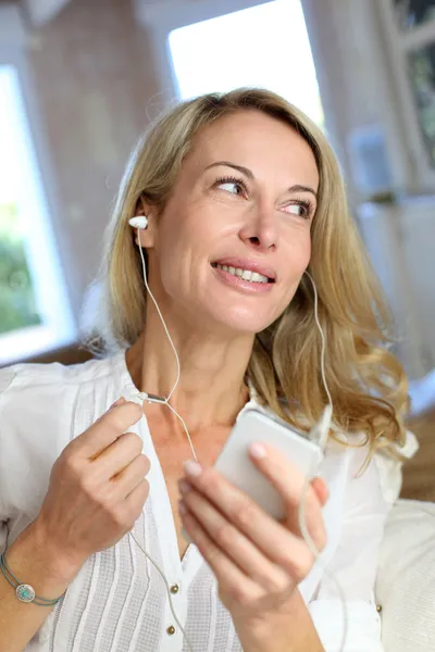Žena středního věku mluví na mobilním telefonu s handfree zařízením — Stock fotografie