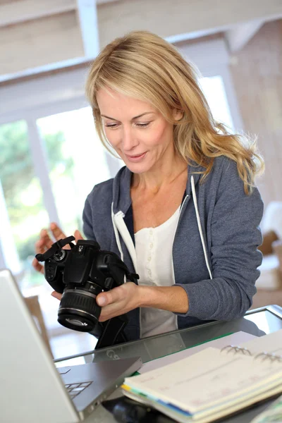 Mujer fotógrafa trabajando desde casa en laptop —  Fotos de Stock