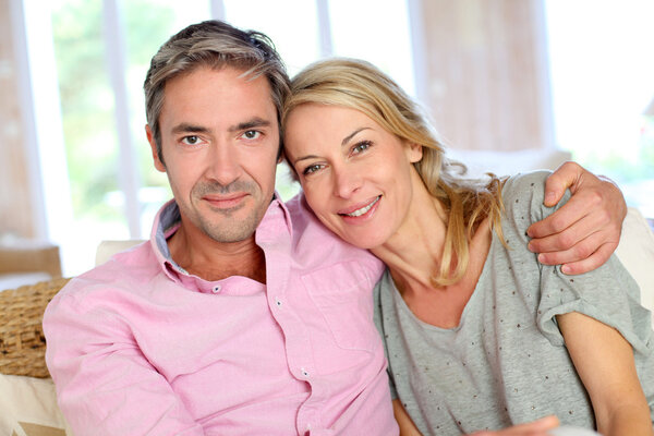 Middle aged couple relaxing in sofa at home