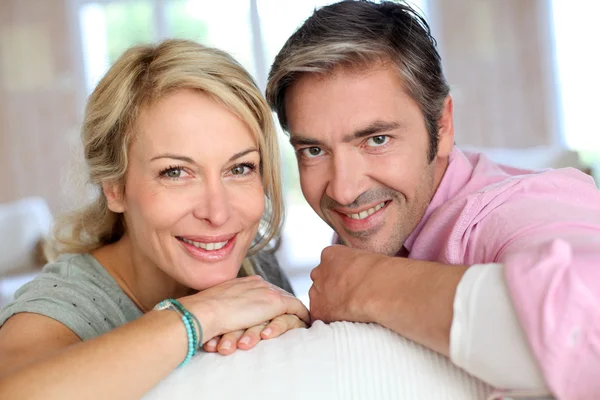 Paar mittleren Alters entspannt auf Sofa zu Hause — Stockfoto