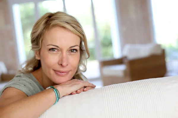 Schöne blonde reife Frau entspannt sich auf dem Sofa — Stockfoto