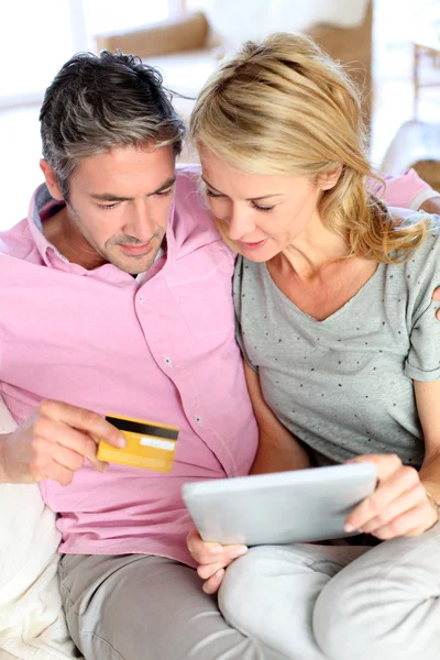 Paret sitter i soffan hemma och gör online shopping — Stockfoto