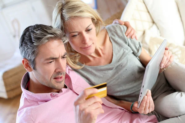 Couple sitting in sofa with electronic tablet — Stock Photo, Image