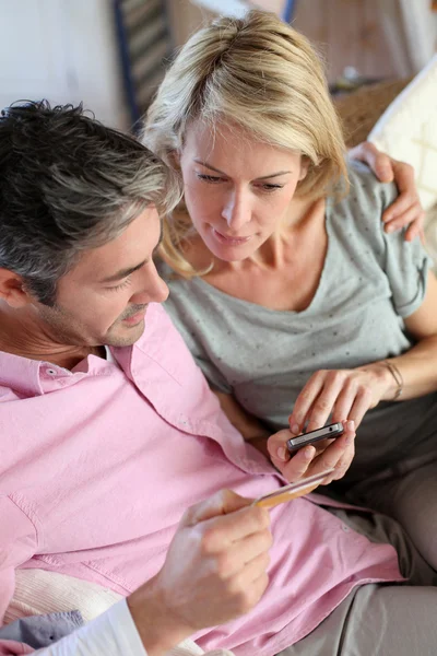 Upper view of couple paying with credit card on mobile phone — Stock Photo, Image