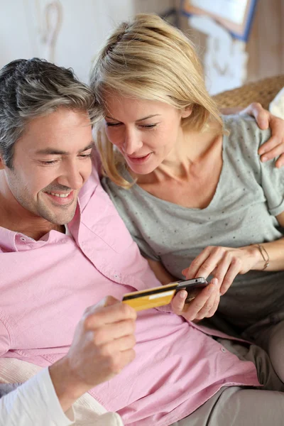 Bovenste weergave van paar betalen met credit card op mobiele telefoon — Stockfoto