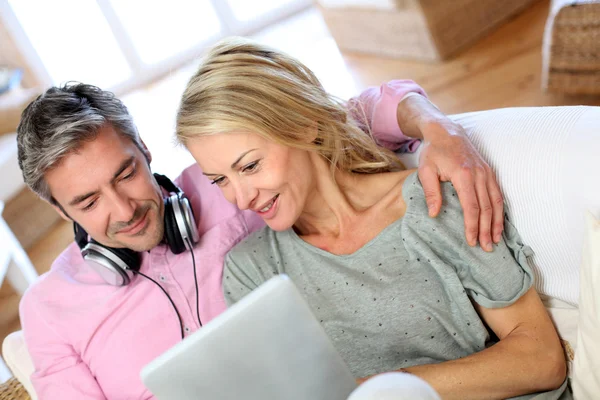 Casal ouvindo música em casa com tablet — Fotografia de Stock