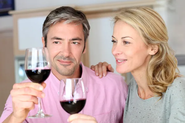 Ζευγάρι πίνοντας κόκκινο κρασί στην κουζίνα — Φωτογραφία Αρχείου