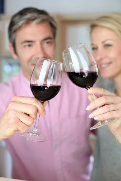 Casal beber vinho tinto na cozinha — Fotografia de Stock