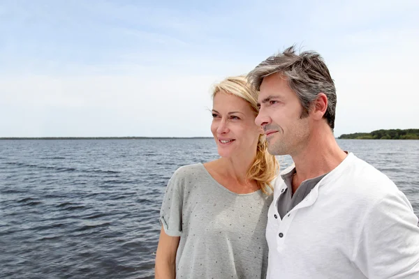 Couple embracing each other on a bridge by a lake — Stock Photo, Image