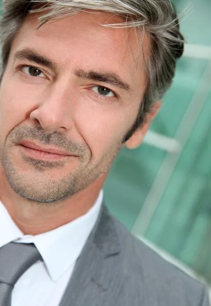 Retrato del hombre de negocios de pie frente al edificio moderno — Foto de Stock