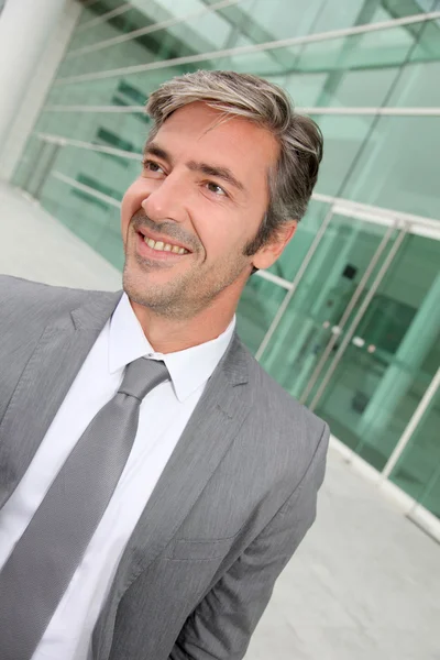 Retrato de homem de negócios em pé em frente ao edifício moderno — Fotografia de Stock