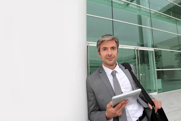 Homme d'affaires debout à l'extérieur du bâtiment avec tablette électronique — Photo