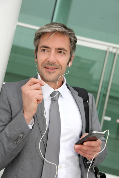 Бізнесмен розмовляє на мобільному телефоні з гарнітурою без рук — стокове фото