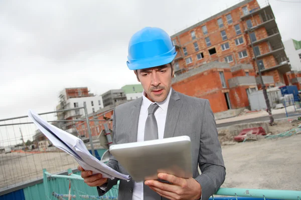 Architekt sprawdzenie planu budowy z tabletem — Zdjęcie stockowe