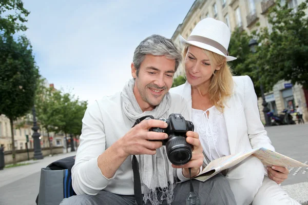 Gelukkig toeristen kijken naar foto 's op camera scherm — Stockfoto