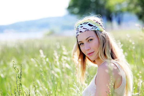 Beautiful blond woman in meadow with modern look Royalty Free Stock Images