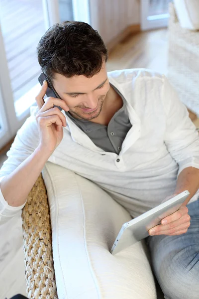 Mężczyzna rozmawia przez telefon podczas używania tabletu Obraz Stockowy