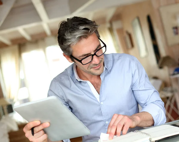 Schöner Geschäftsmann mit Brille, der von zu Hause aus arbeitet lizenzfreie Stockfotos