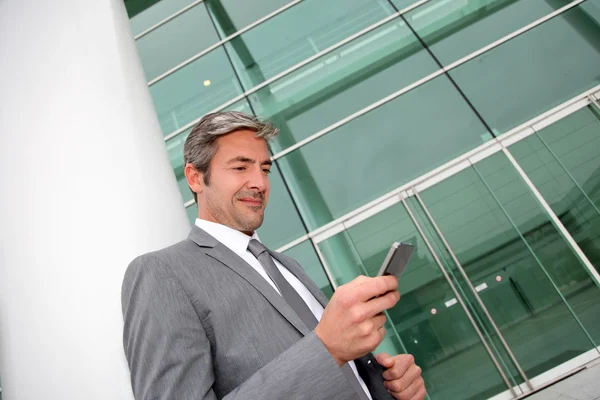 Businessman writing short message on mobile phone Stock Image