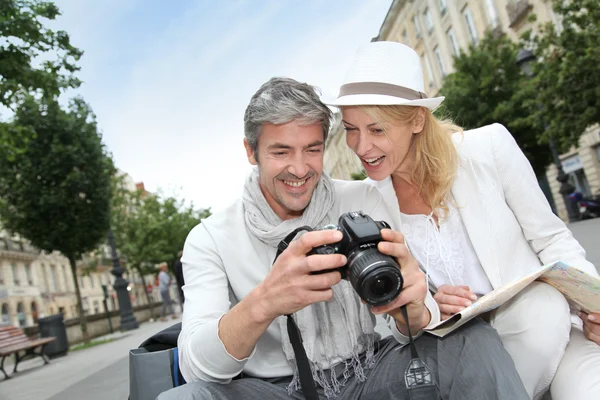 Happy tourists looking at pictures on camera screen Stock Picture