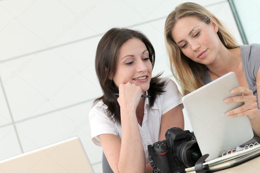 Women photographers working in office with tablet