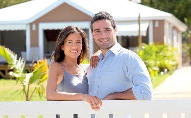 Couple standing in front of new home clipart