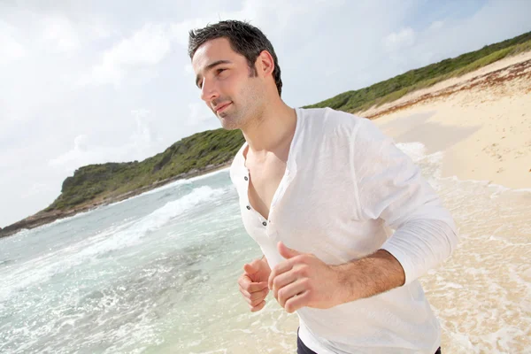 Hombre corriendo en una playa de arena —  Fotos de Stock