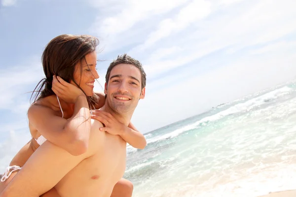 Portrait of man carrying girlfriend on his back — Stock Photo, Image