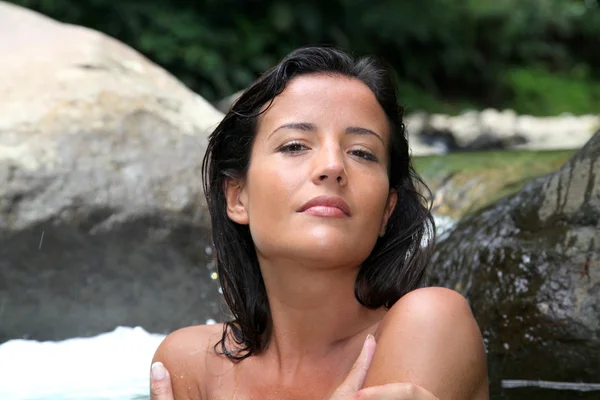 Aantrekkelijke brunette vrouw nemen van een bad in de rivier — Stockfoto