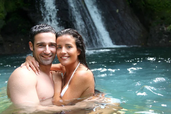 Happy couple bathing near waterfall in island — Stock Photo, Image
