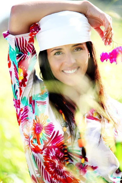 Beautiful gypsy girl with scarf standing in meadow — Stock Photo, Image