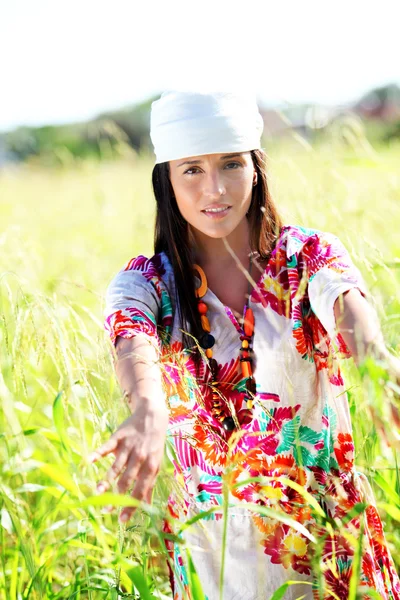 Beautiful gypsy girl with scarf standing in meadow — Stock Photo, Image