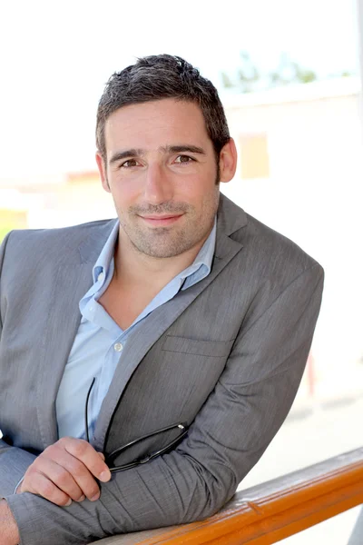 Portrait of confident salesman leaning on balustrade — Stock Photo, Image