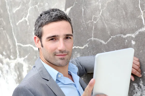 Businessman using electronic tablet outside the office — Stock Photo, Image